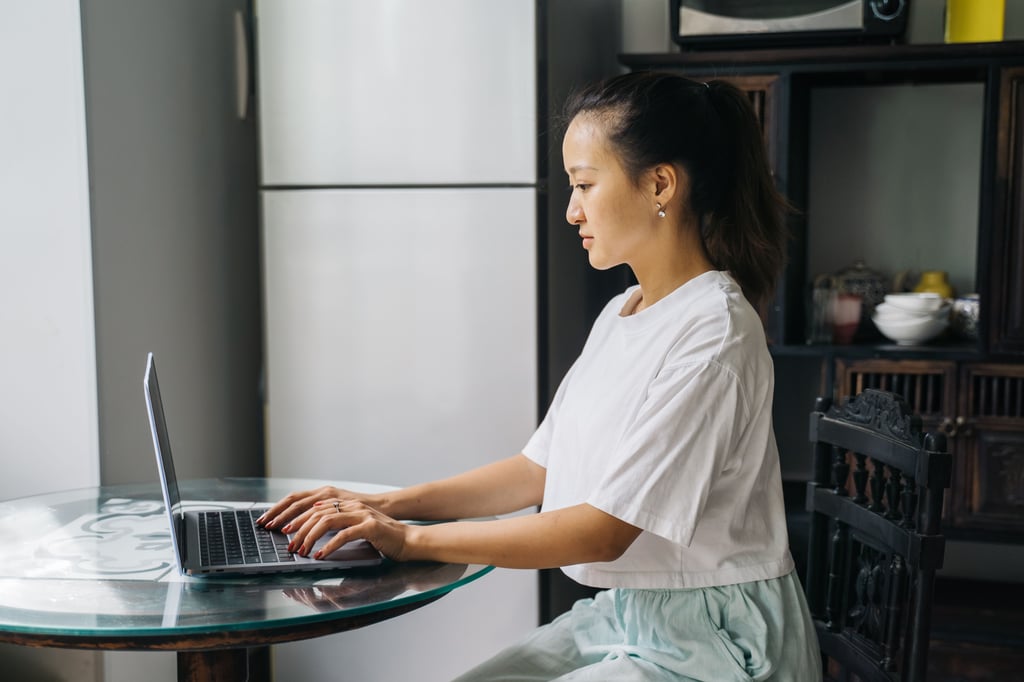 International student on a laptop in their apartment.