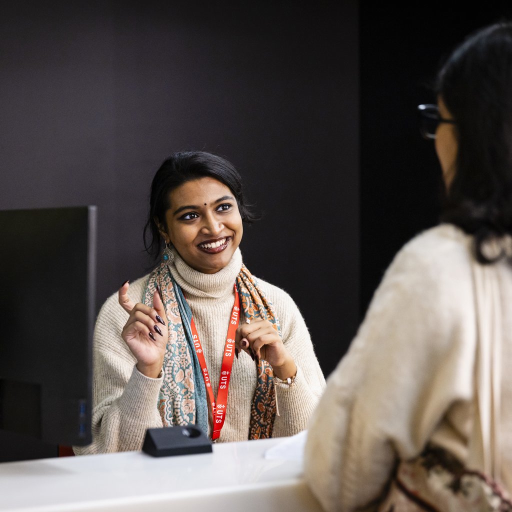 Student adviser talking to student at an on-campus help desk.