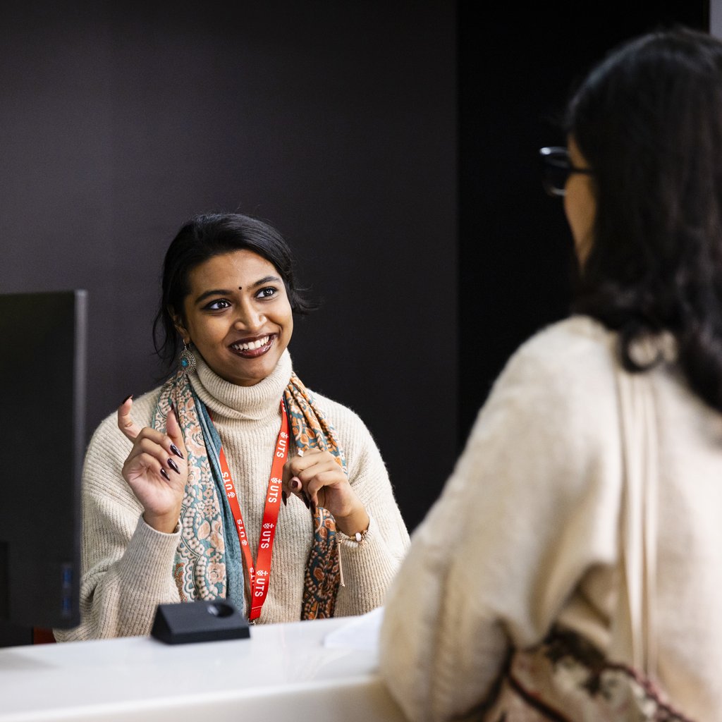 International advisor talking to international student at support desk.