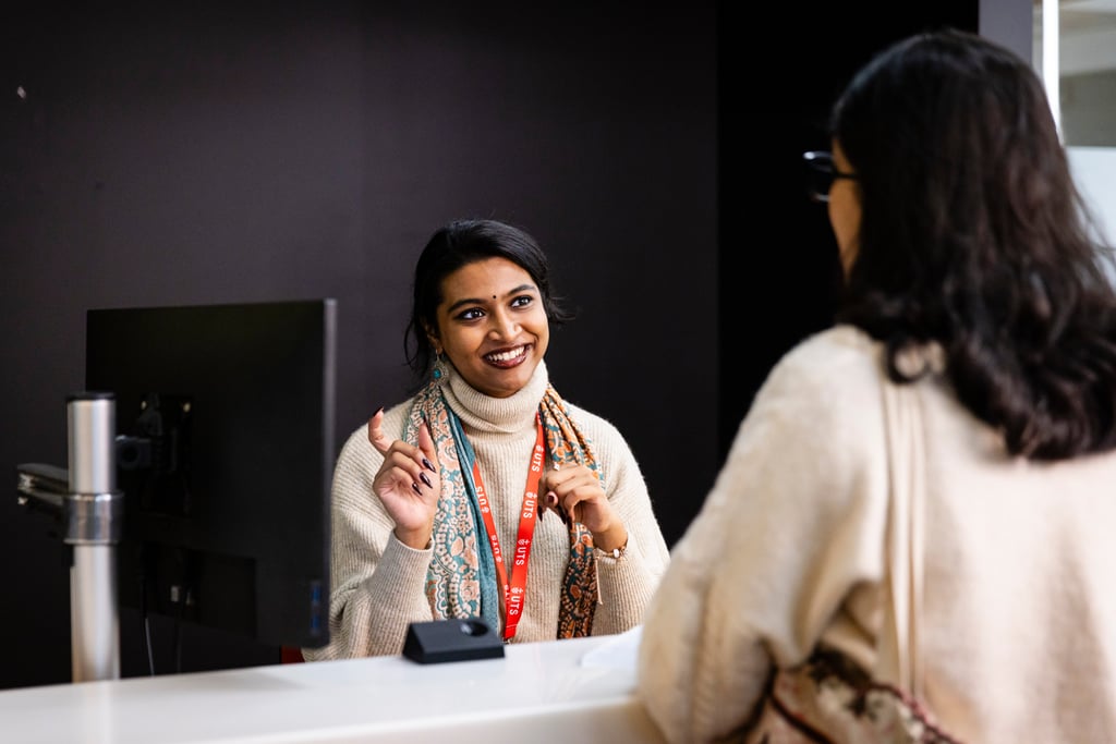 UTS advisor consults with a student at a campus help desk.