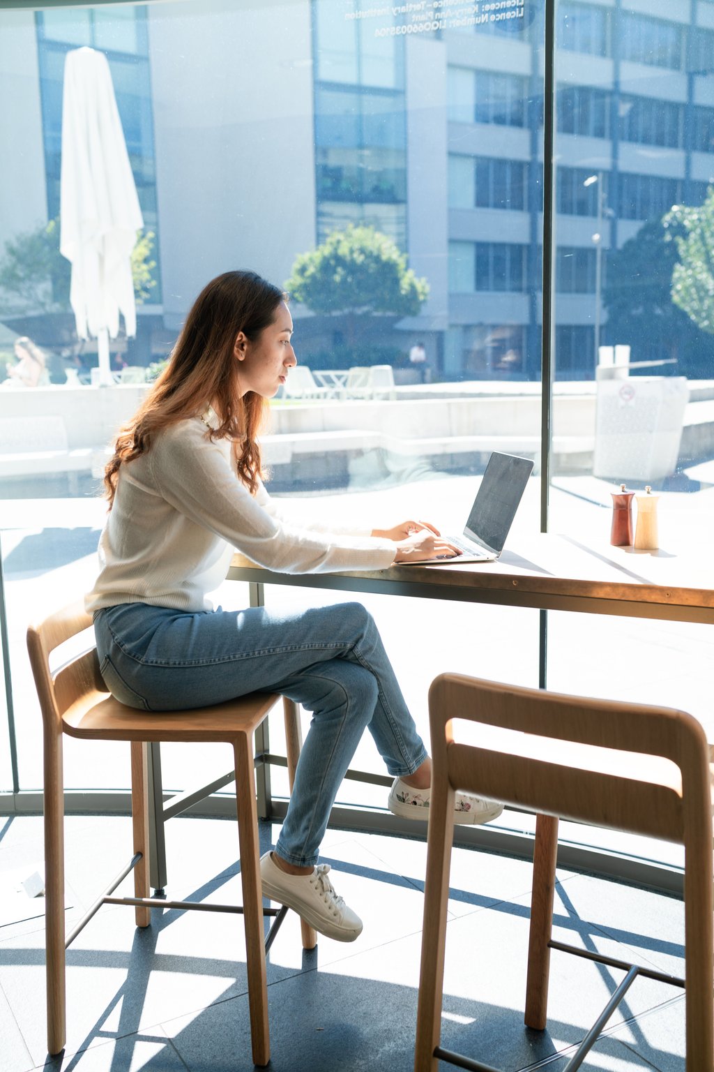 Student on laptop in cafe on-campus.