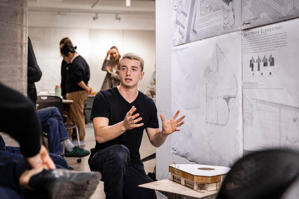 A group of people review an architecture student's work.