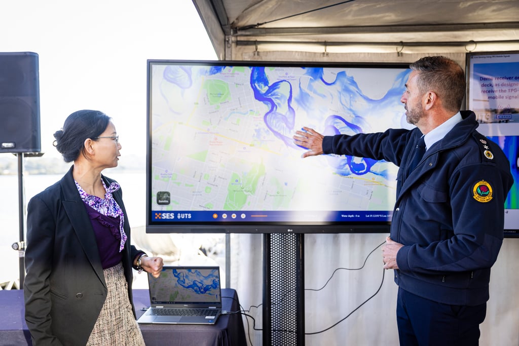 Associate Professor Wenjing Jia and Commissioner Mike Wassing demonstrate the digital twin on a large screen