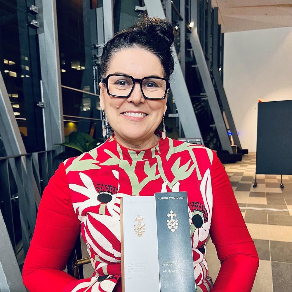 Alana Valentine with her award trophies at an award dinner in February 2022. Alana is wearing the design of Indigenous artist Deborah Wurrkidj from Arnhem Land whose silkscreen on linen piece 'Manwak (Mumeka Blooms)' Alana made into her outfit.