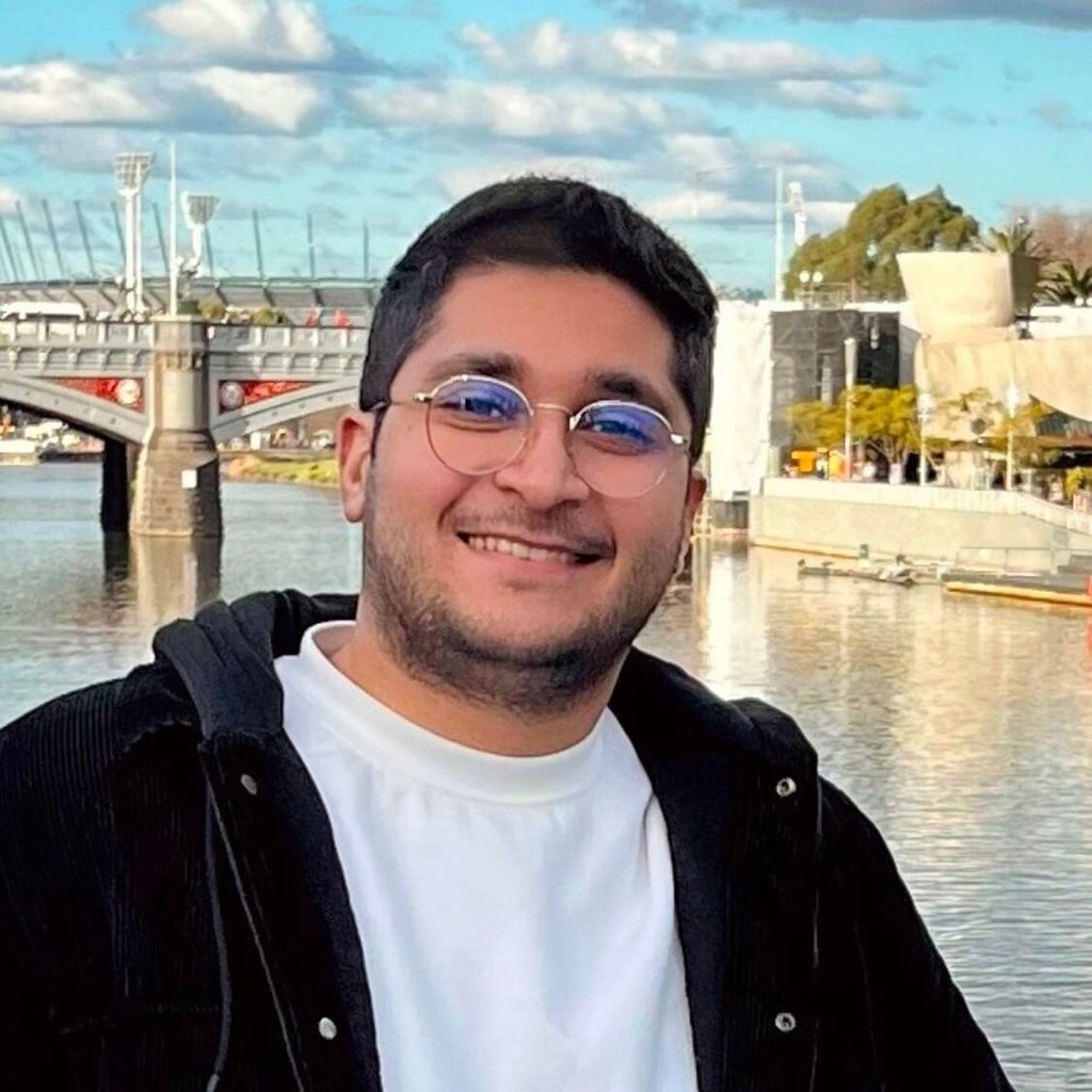 Arian smiling in front of a bridge and water.