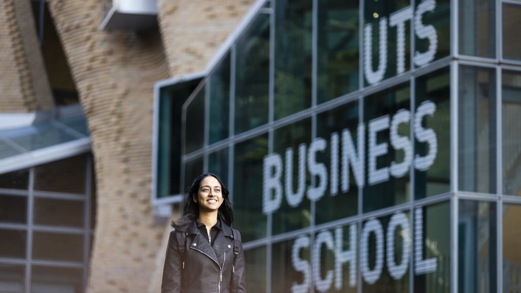 Woman walking in front of UTS Business School building.