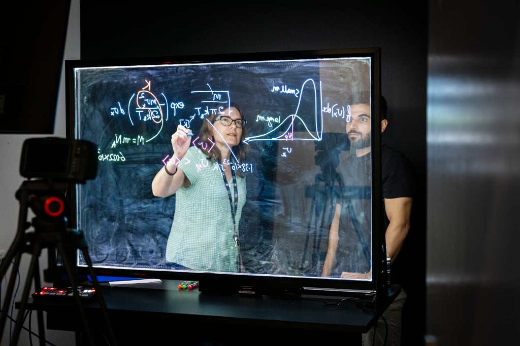 Image of two people completing mathematics equations on screen