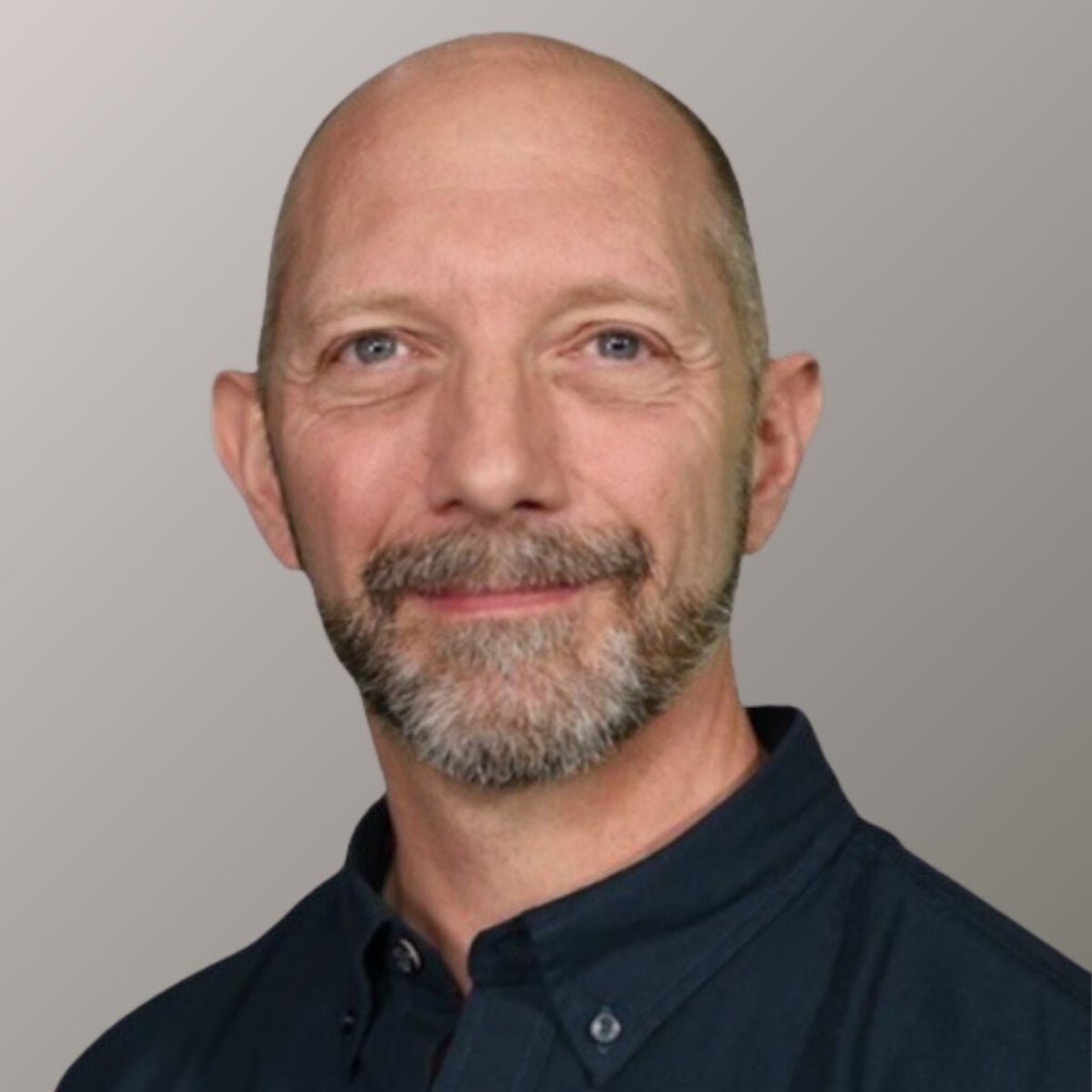 Portrait of Dr Jochen Schweitzer, he's wearing a black dress shirt.