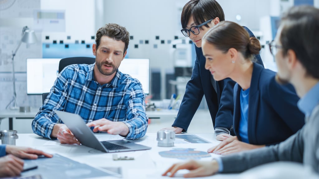 Diverse team of professionals discussing ideas around a laptop