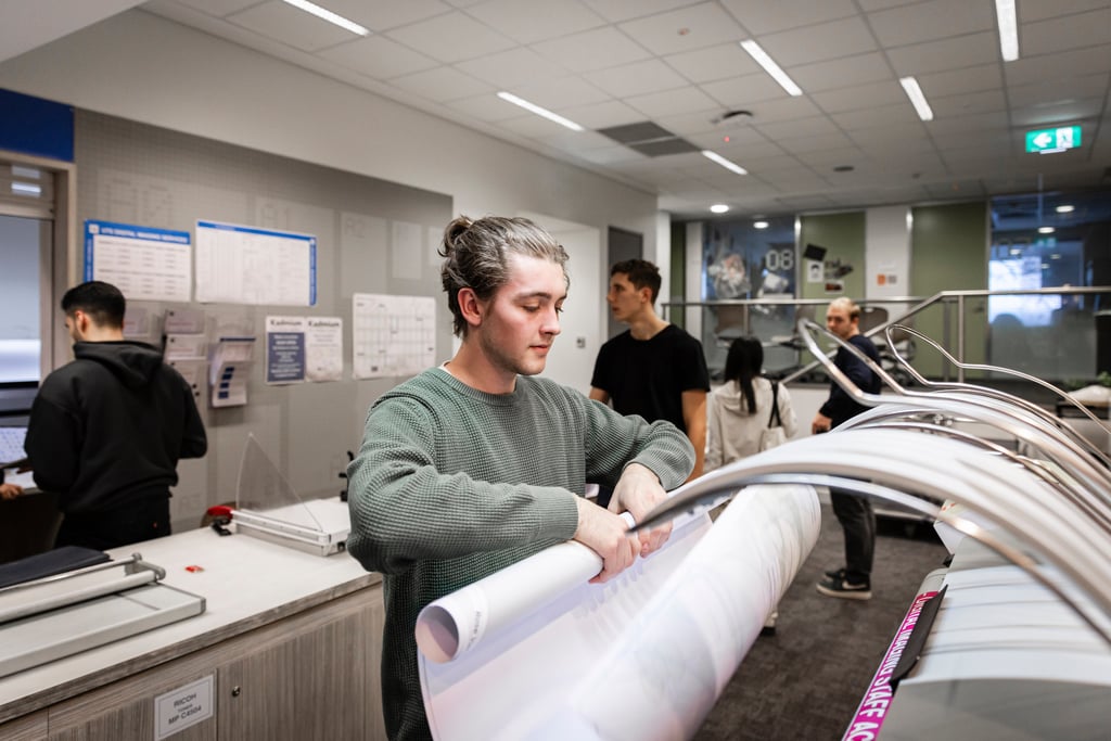 A student collecting their work from the printing services at UTS.