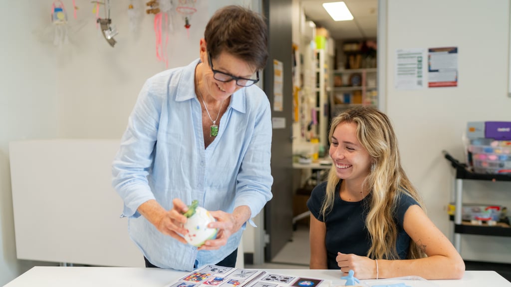 UTS academic helping a UTS student in a ceramics class.