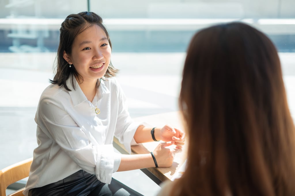 A young woman smiling while talking to an advisor