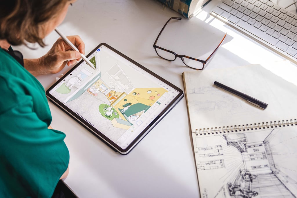 Dr Samantha Donnelly sketching on her iPad at a desk, guided by earlier paper drawings.