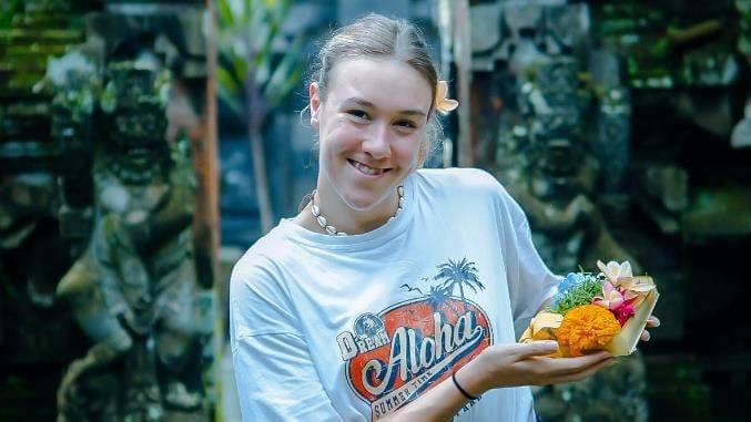 UTS student holding bowl of flowers.