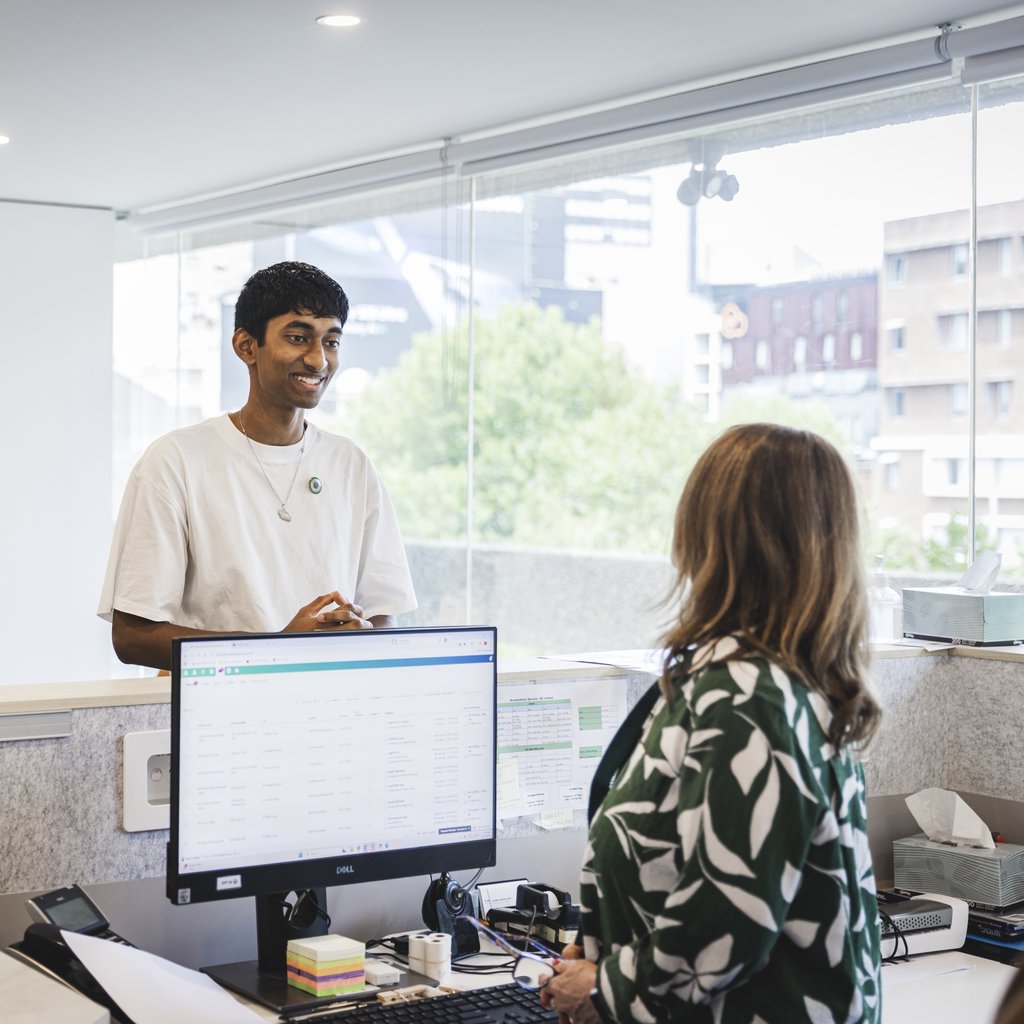 Student at an on campus health clinic talking to a medical receptionist