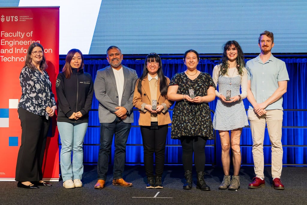Image of Tech Fest award recipients on stage. The recipients are pictured smiling with their Tech Fest trophies in hand