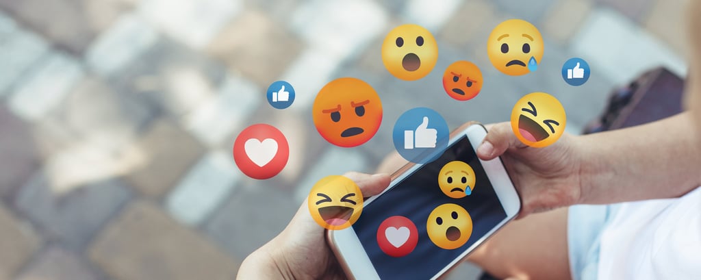 childs hand on phone with emojis
