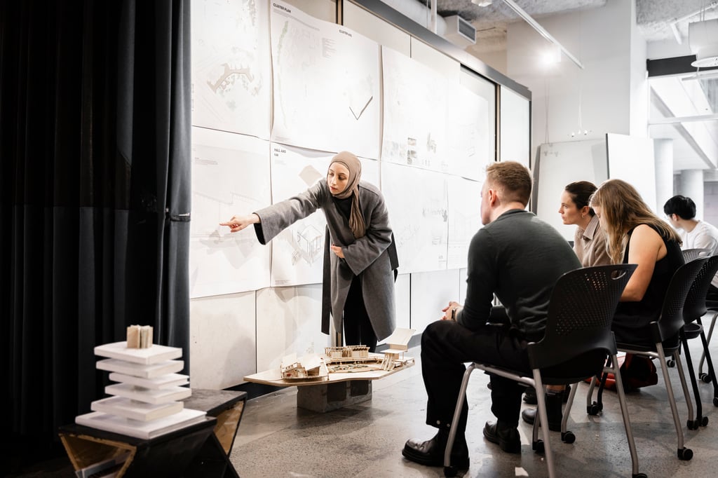 A group of people review an Architecture student's work.