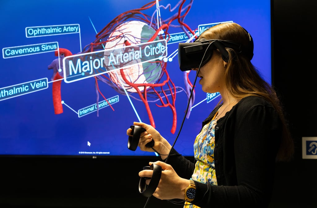 Woman using a virtual reality headset with a medical view of an eye on a screen behind her.