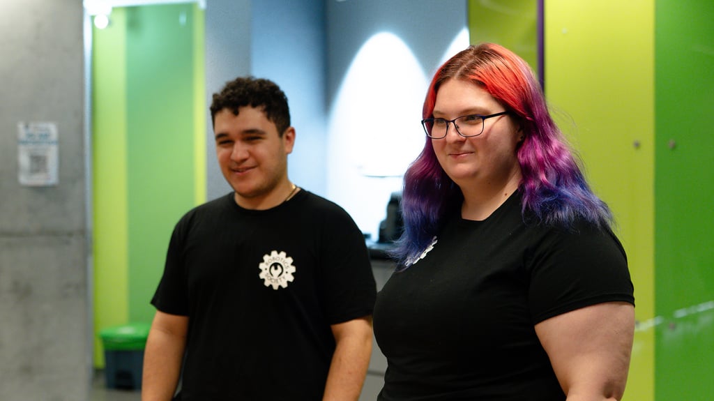 Two people in front of a green background