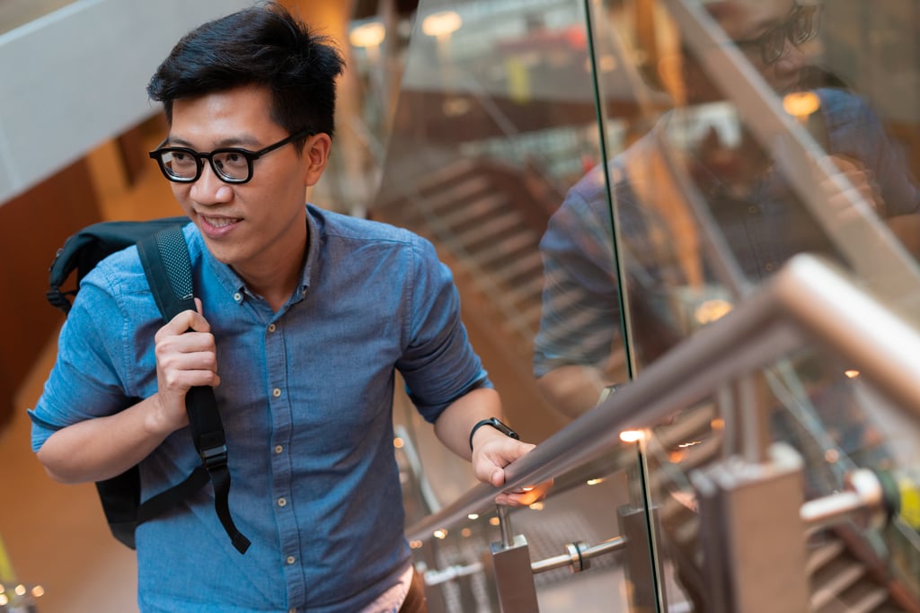 Student holding the railing while walking upstairs.