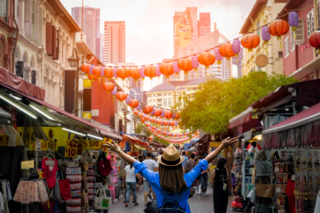Young woman traveler with backpack and hat traveling into Chinatown at Singapore city downtown.