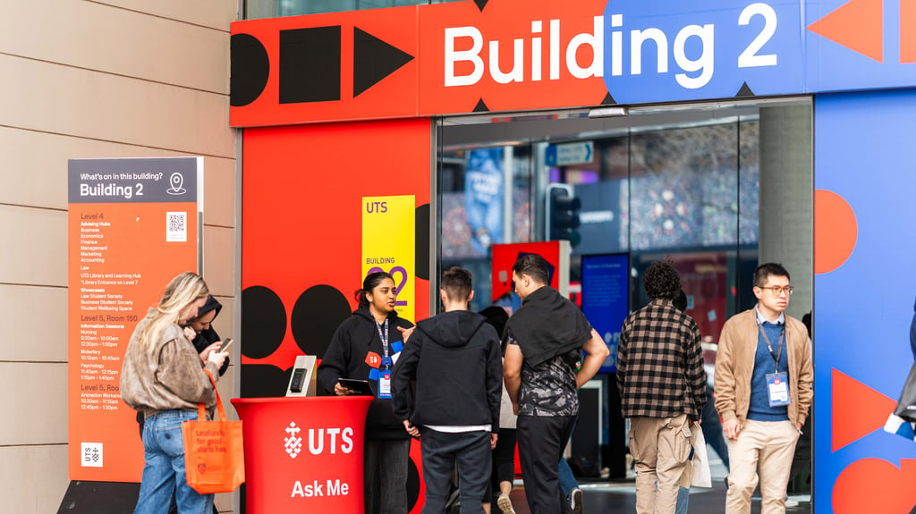 Several prospective students are gathered outside a building marked with a sign that says "Building 2" at University of Technology Sydney.