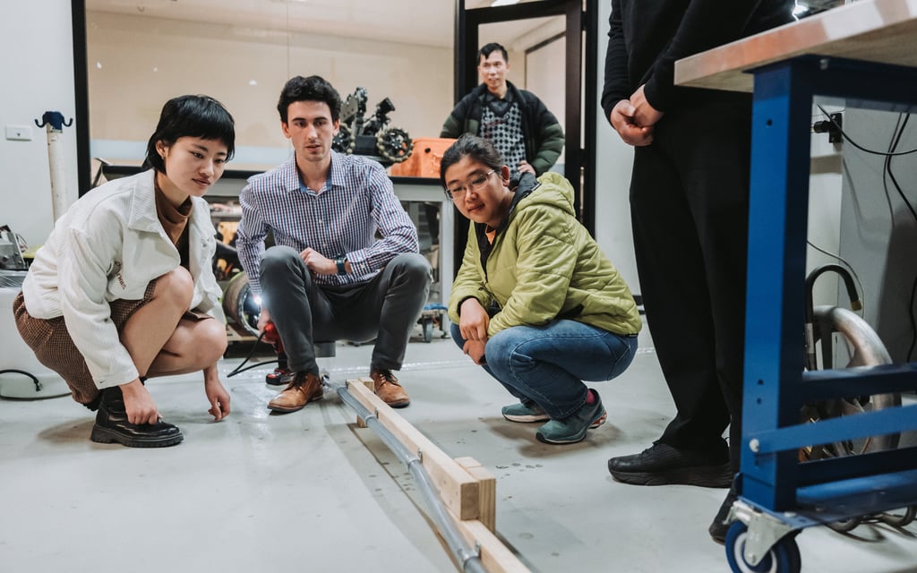 The team crouch, watching the experiment