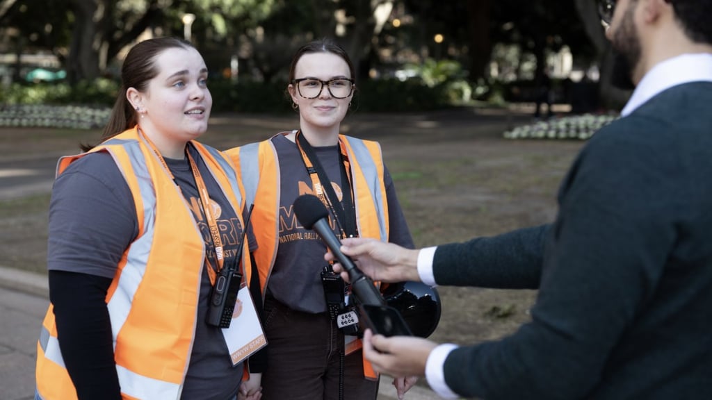 Amelia Wilson-Williams and a fellow volunteer speaking to media at a rally against domestic, family and sexual violence.