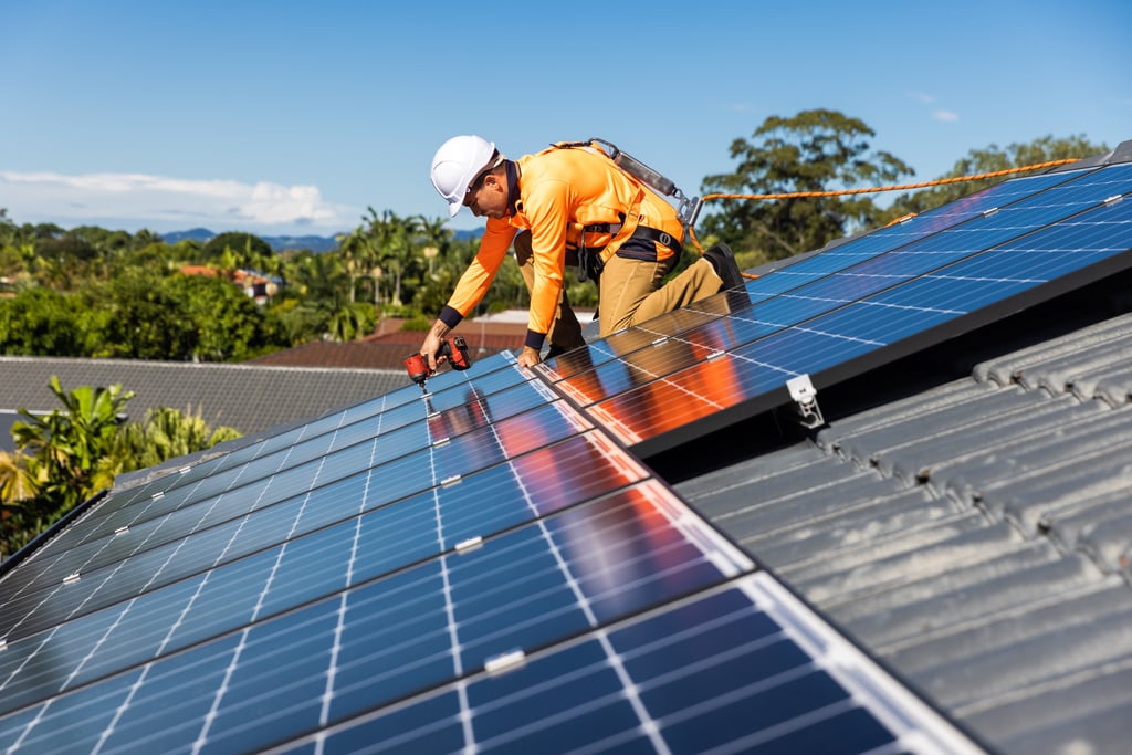 Solar panel technician with drill installing solar panels. Picture by Zstock/Adobe Stock