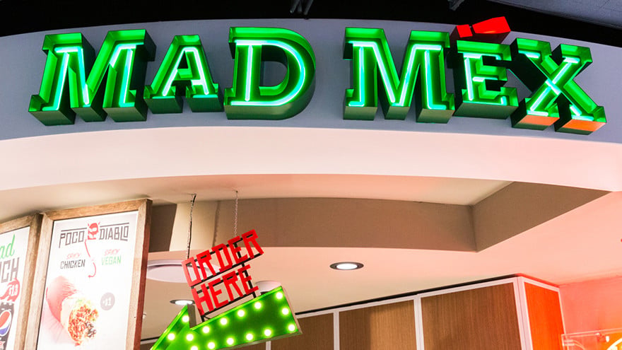 Green neon lights spell out Mad Mex