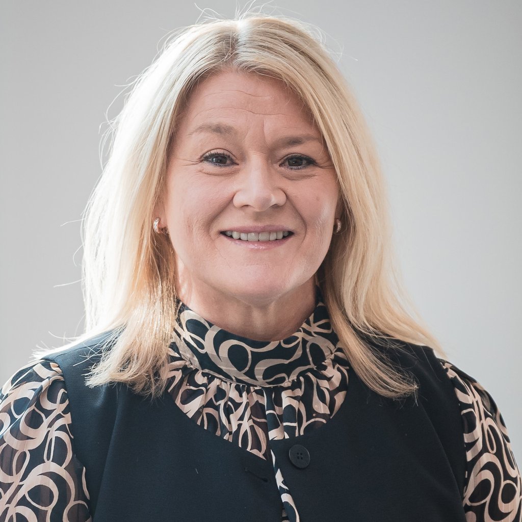 Profile image of Debbie in front of a grey wall