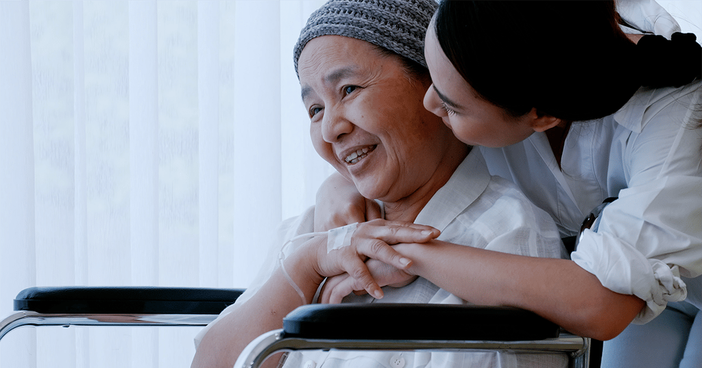 Mother in wheelchair being hugged by daughter.