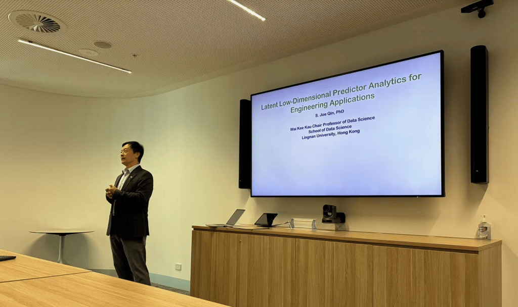 Professor Joe Qin presenting “Latent Low-Dimensional Predictor Analytics for Engineering Applications” beside a large presentation screen during an AAII research seminar.