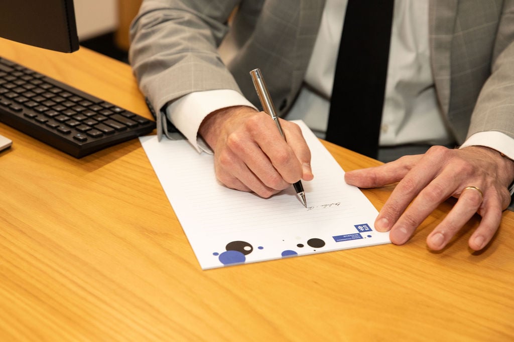 Person writing on paper at a desk
