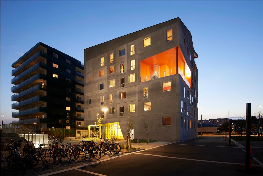 Exterior shot taking in the whole Aarhus Student Housing building at night with the internal lights on.