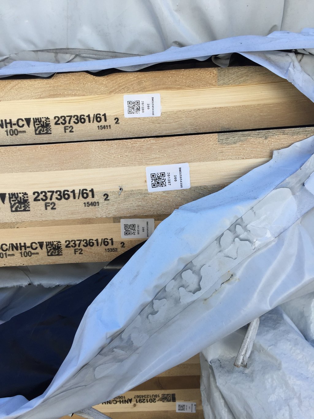 Close up of the timber with its plastic wrap pulled aside showing the QR code on each piece.