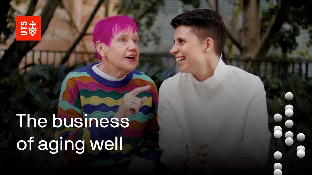 The words business of ageing well appear beneath Nicole and Gwenda as they laugh at something they're discussing while seated outside the UTS Business School.