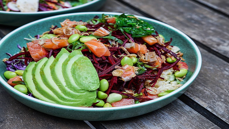 A plate filled with a salmon and avocado salad