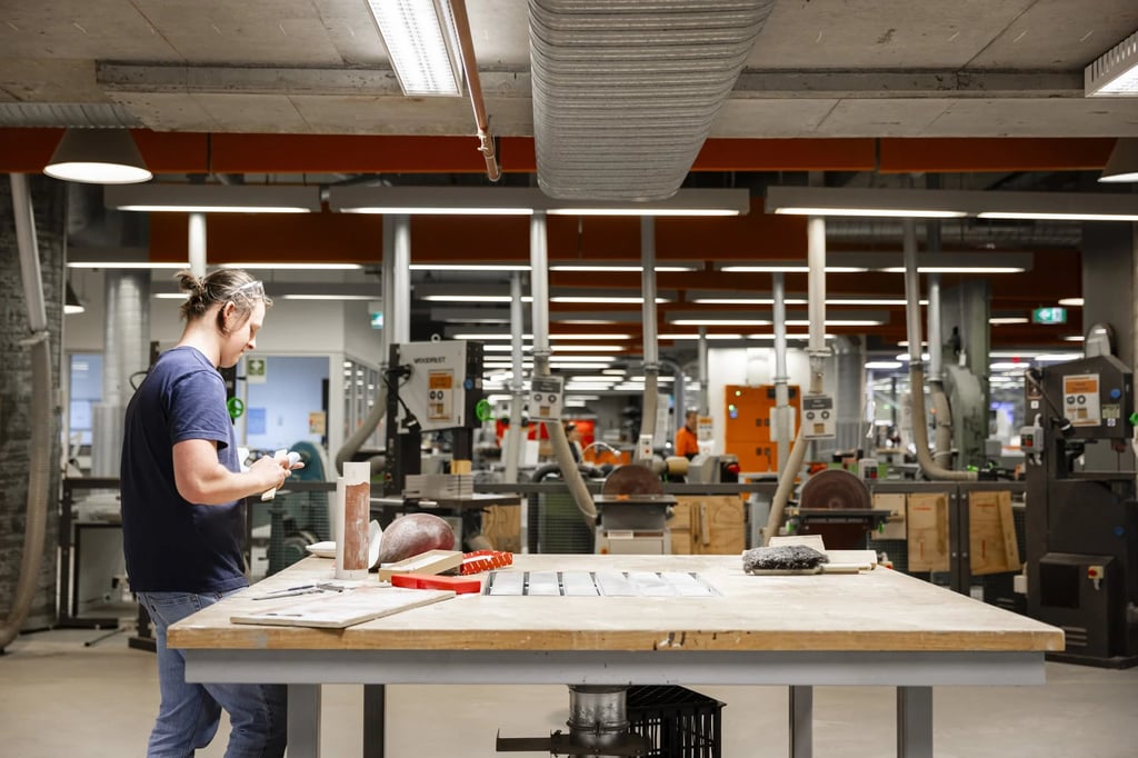 University student at a wooden workbench in the fabrication workshop