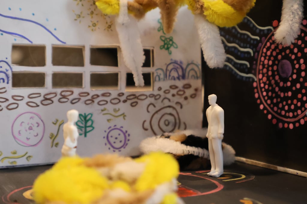 Close-up of scale figures in an architecture scale model with Indigenous artwork
