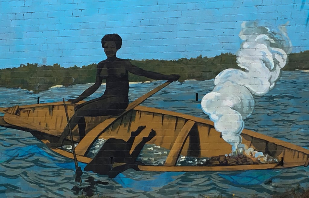 A painting depicting a man rowing a boat on calm water, surrounded by a serene landscape.