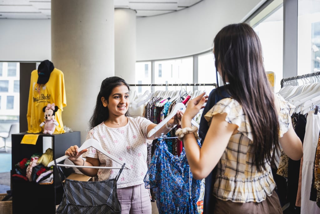 Students selecting clothing off a rack.
