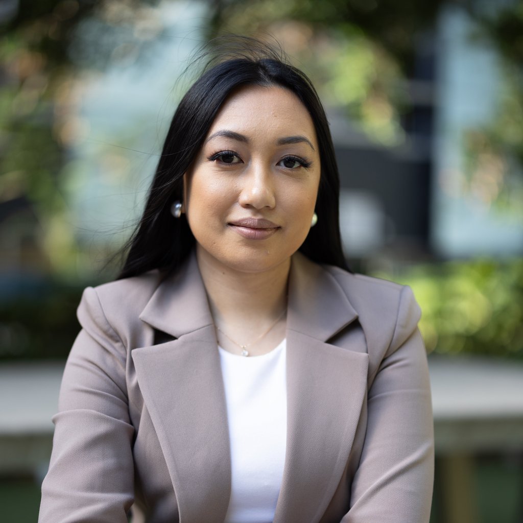 Arhita wearing a light brown blazer over a white top