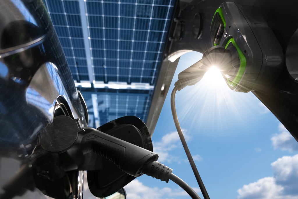 An electric car plugged into a charging station on a sunny day.