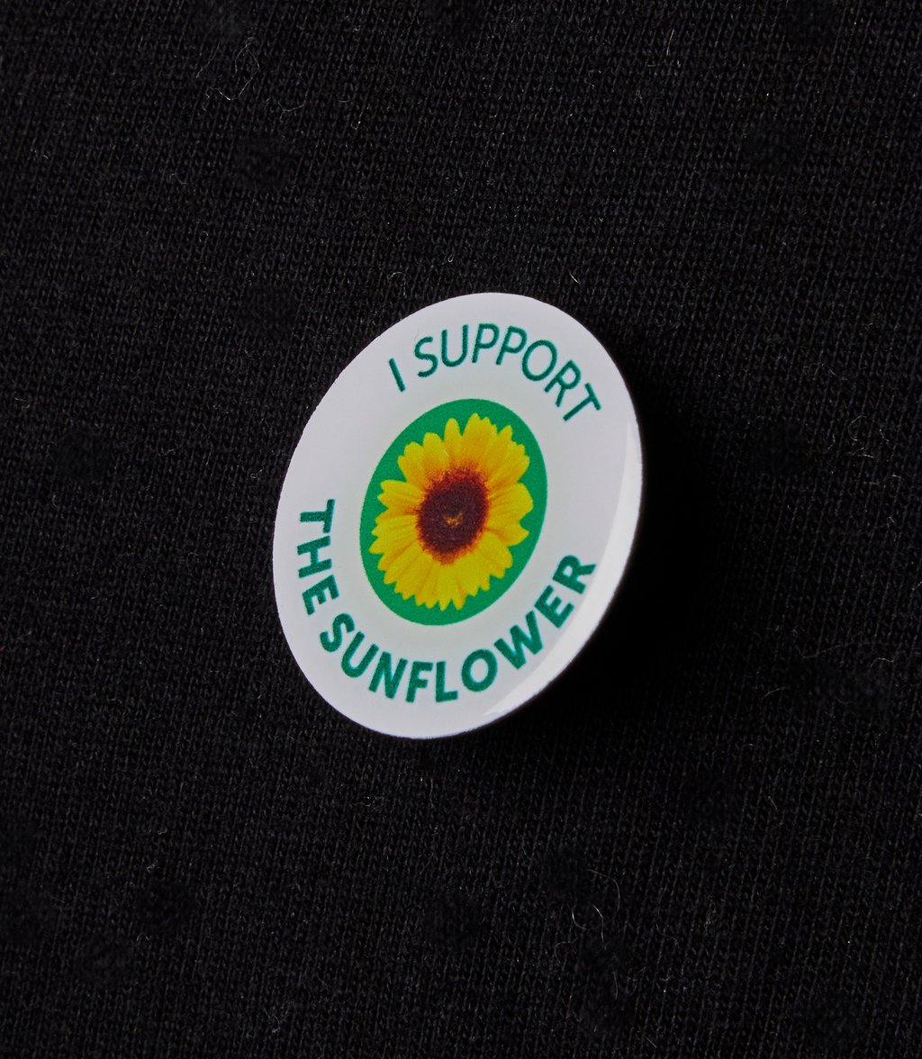 Badge reading I support the sunflower