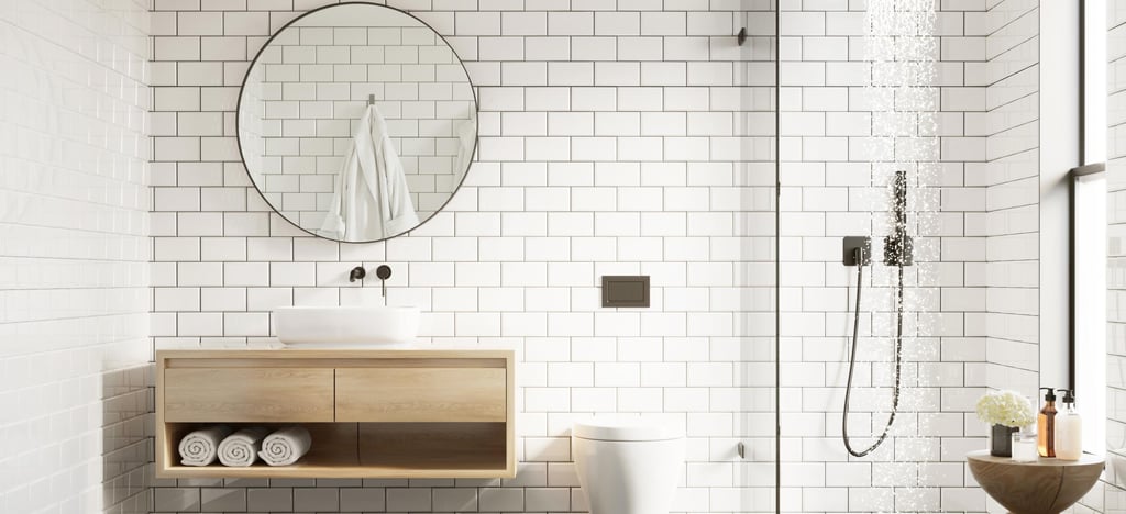 Modern bathroom with white subway tiles, round mirror, and wooden vanity with sink. Minimalist shower, natural light, towels, and flowers evoke tranquility.