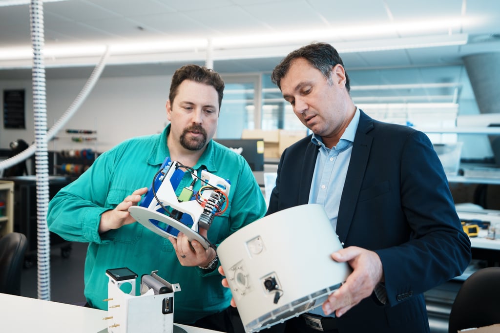 Two UTS Rapido Mechatronic engineers in a lab environment holding newly built coral camera equipment