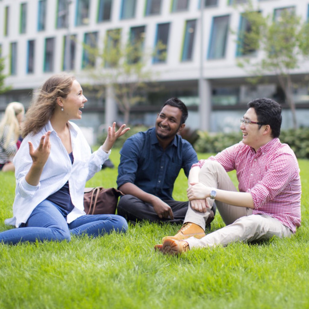UTS students sitting on Alumni Green, talking.