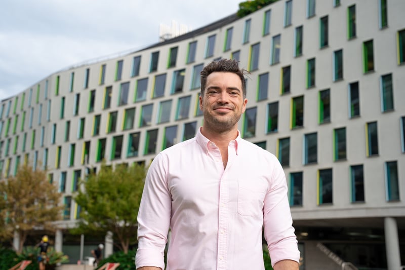 Photo of UTS law student Mark Curry standing in front of UTS building smiling into the camera